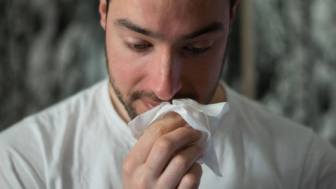 Uomo che si soffia il naso