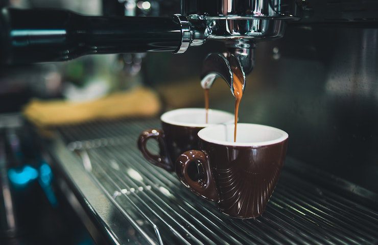 Macchinetta del caffè in funzione in un bar mentre fa due espressi