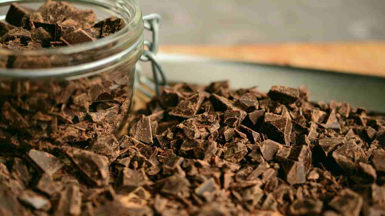 Cioccolato fondente a pezzi in un barattolo e in un piatto