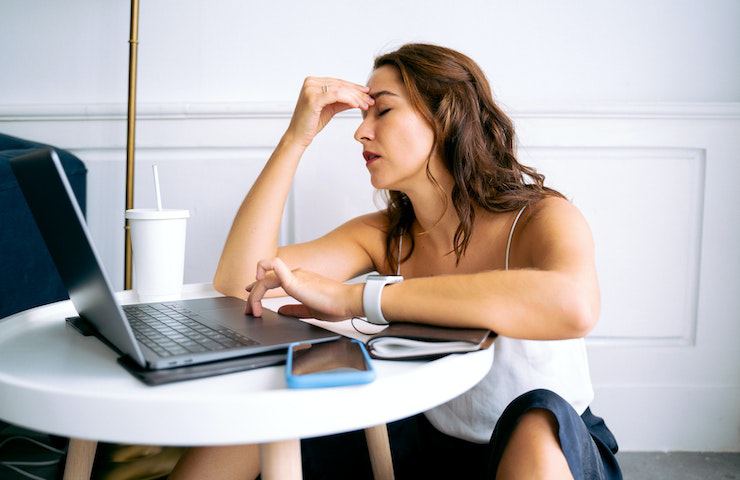 Donna che fa fatica a concentrarsi mentre usa il pc