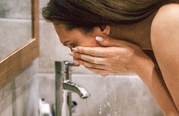 Una ragazza lava il suo viso