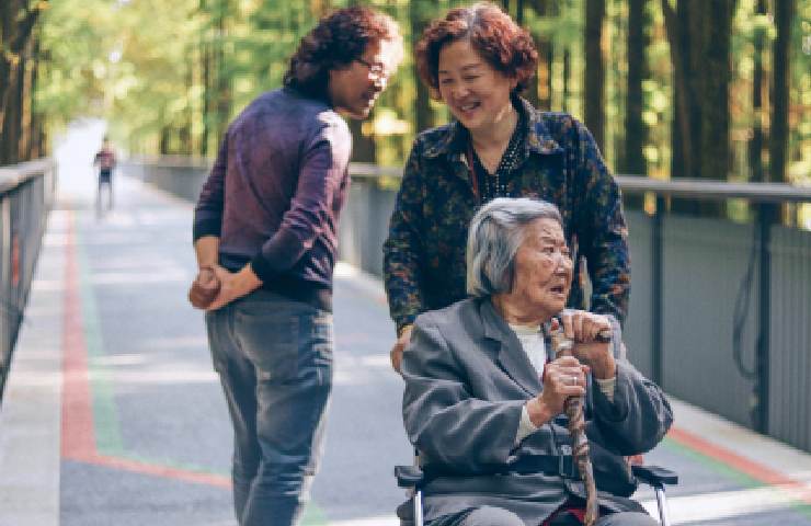 Donna sorridente che porta a passeggio una signora 