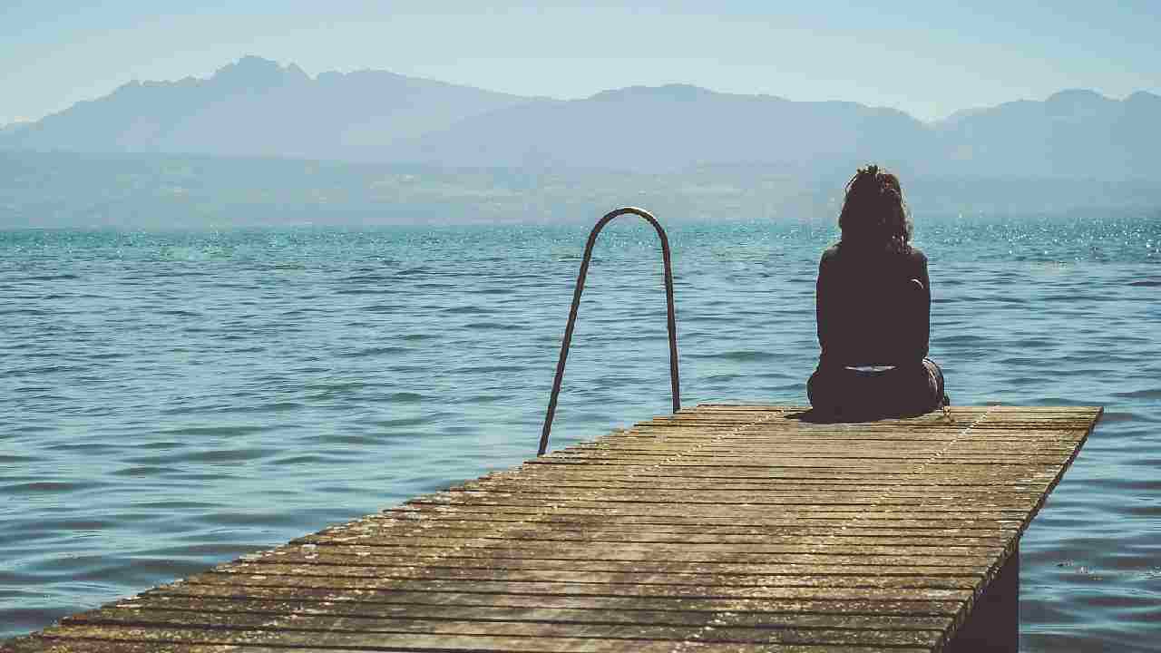 Una donna sola di fronte al mare