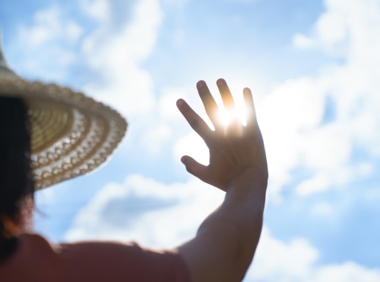 ragazza copre con la mano il sole cocente estivo