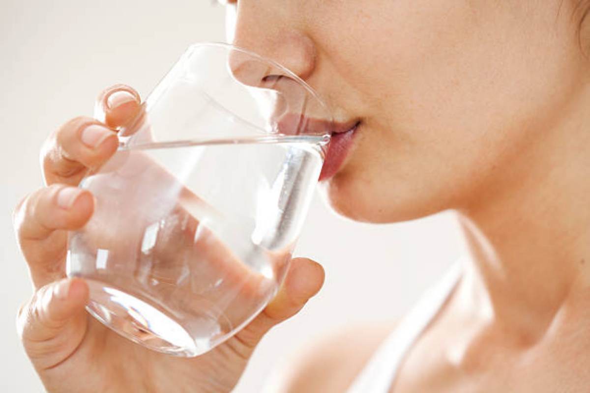 Ragazza beve un bichhiere d'acqua