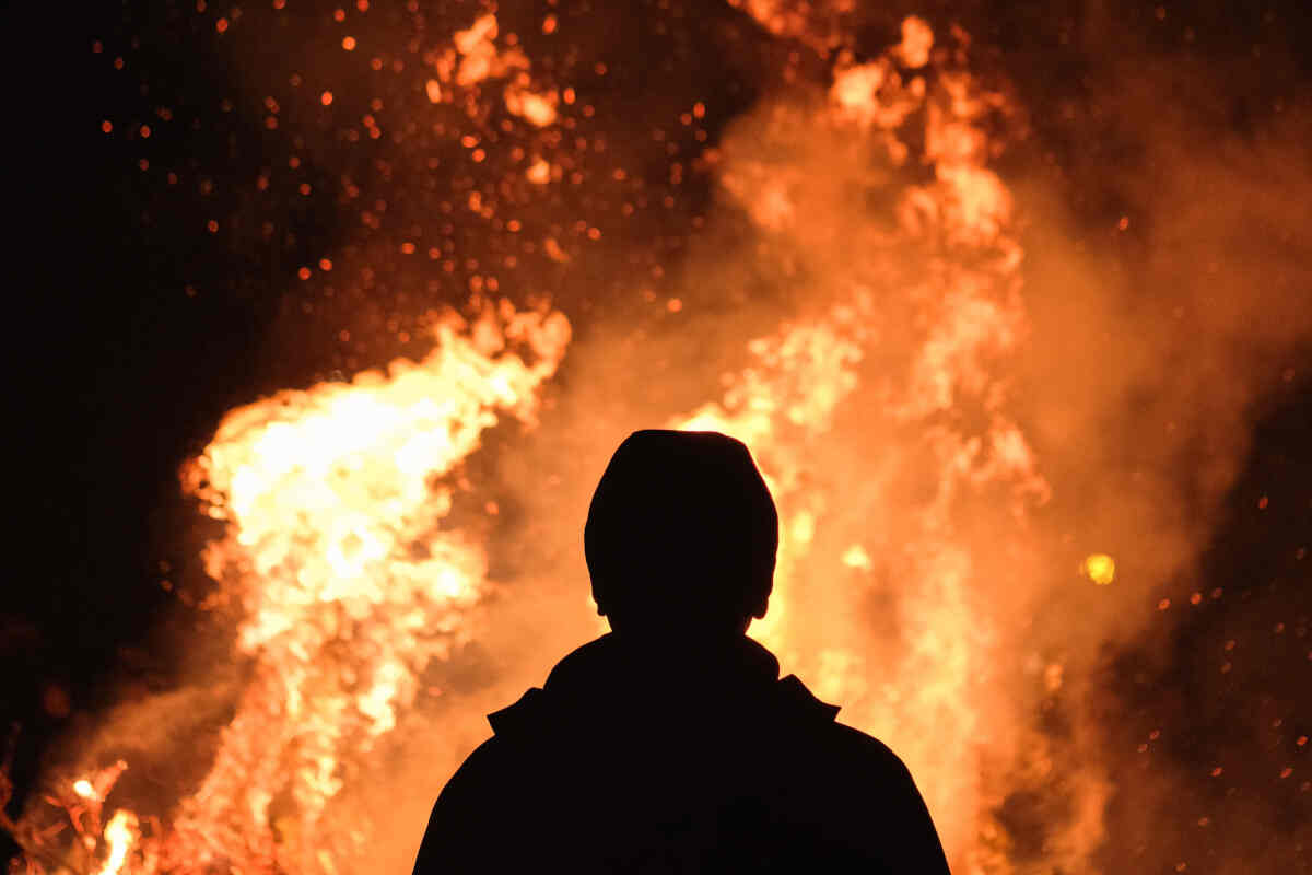 Un uomo guarda un incendio