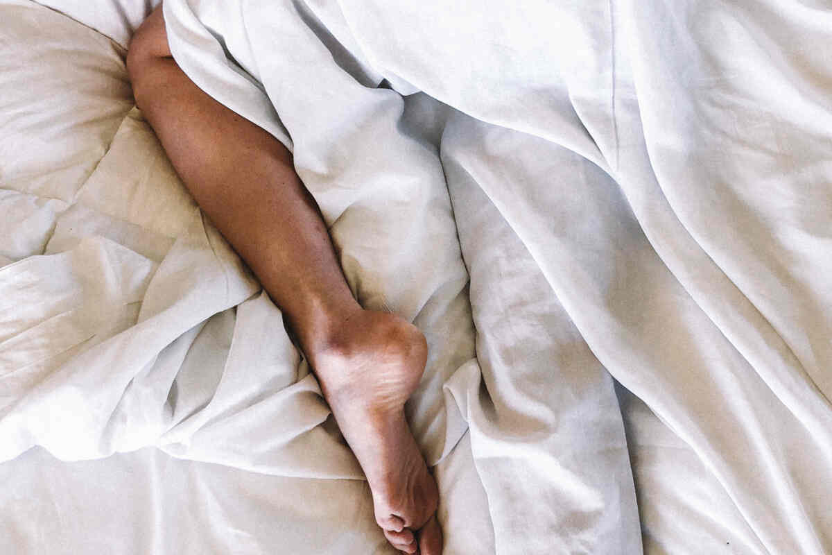 Piede nudo esce da sotto una coperta