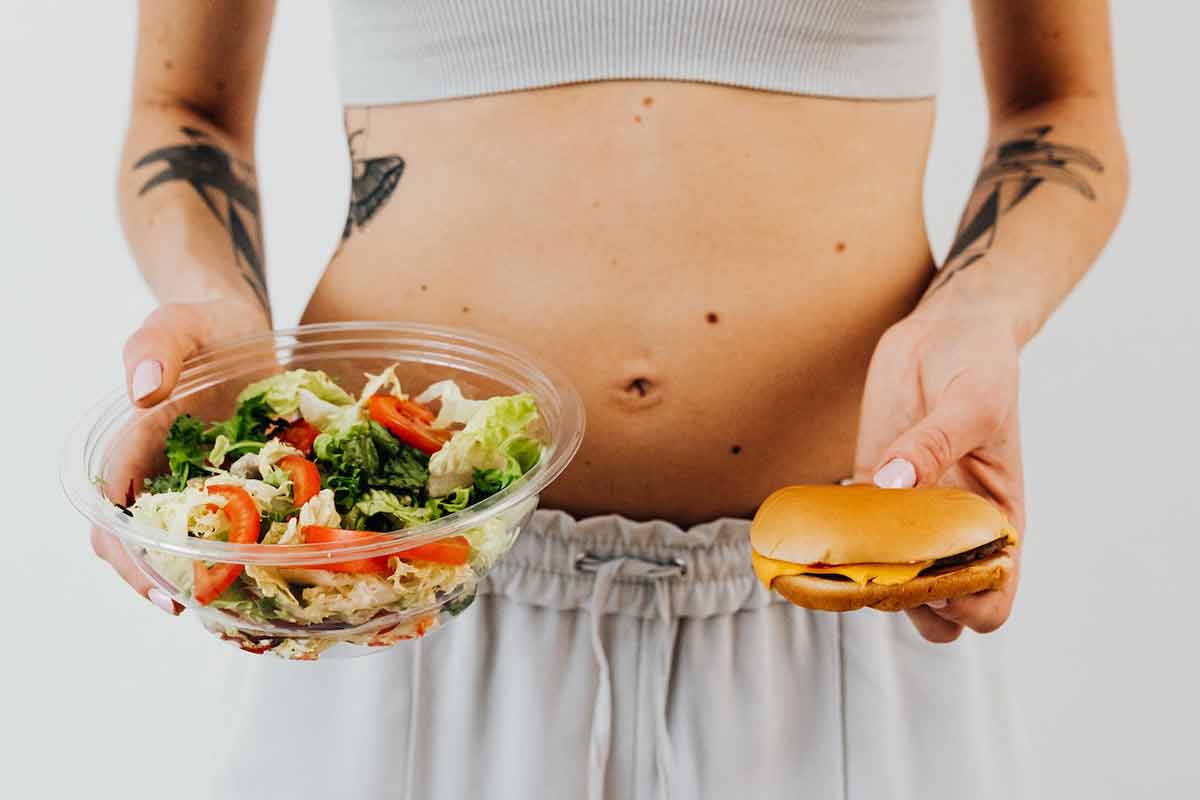 una ragazza che sceglie tra un panino e un'insalata