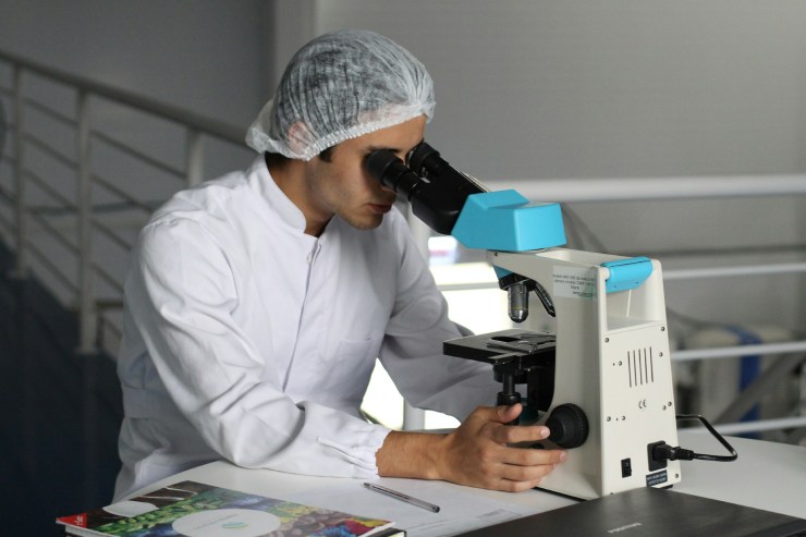Medico di laboratorio osserva al microscopio