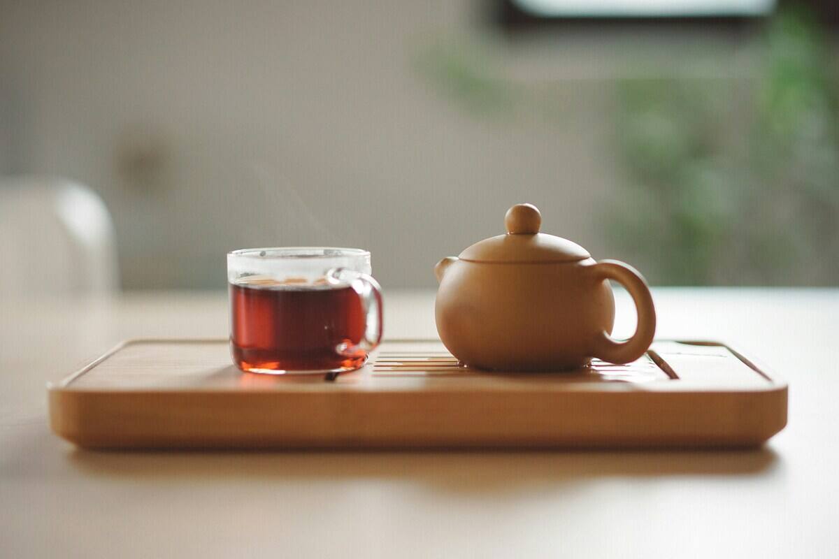 bicchiere di tè con teiera in legno