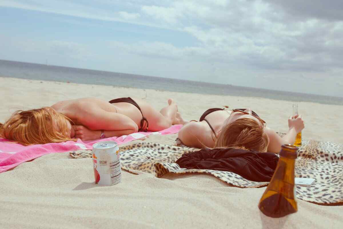 ragazze si abbronzano in spiaggia