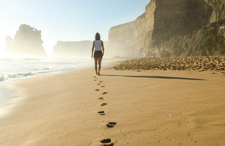 donna cammina sulla spiaggia