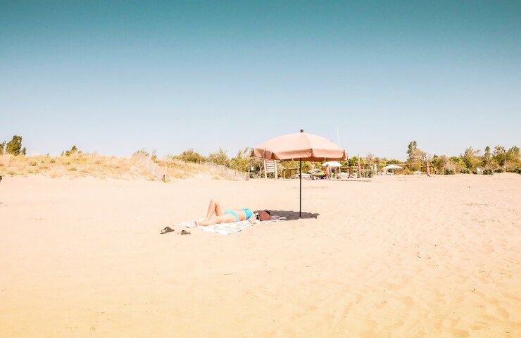 donna in spiaggia che si abbronza