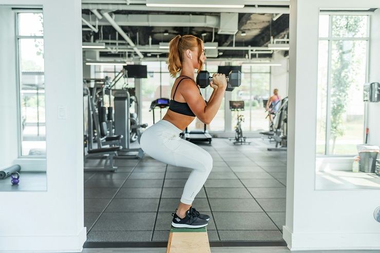 Una ragazza intenta a fare gli squat